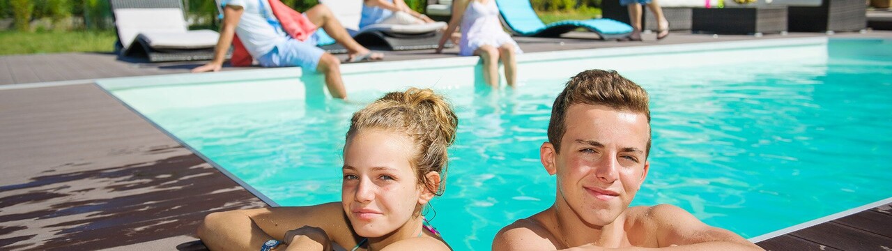 ap_zwembad.jpg jongen en meisje hangend op rand zwembad