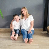 mama en zoon op betegelde vloer living